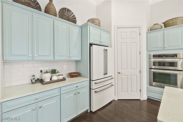 kitchen featuring backsplash, dark wood-type flooring, high end fridge, blue cabinetry, and stainless steel double oven