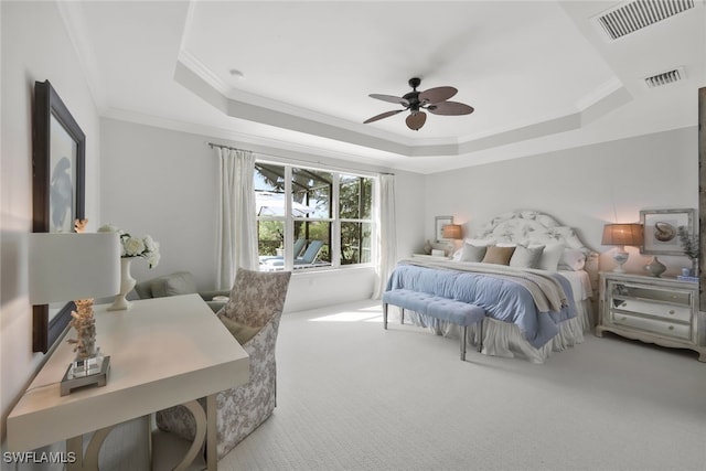 bedroom featuring ornamental molding, carpet, ceiling fan, and a tray ceiling