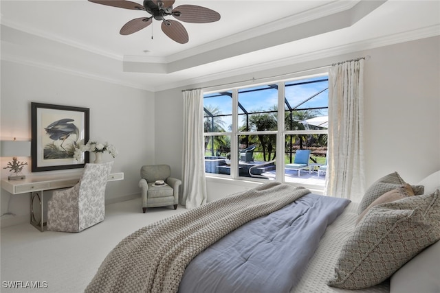 bedroom featuring crown molding, a tray ceiling, carpet floors, and ceiling fan