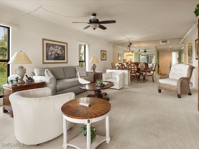 living room with ceiling fan, ornamental molding, plenty of natural light, and light carpet