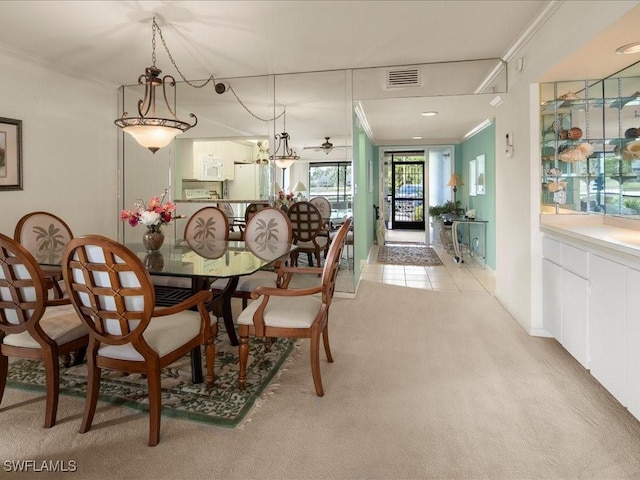 carpeted dining room featuring crown molding