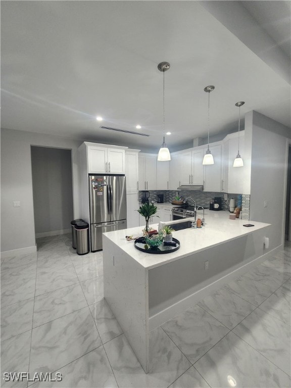 kitchen featuring white cabinets, hanging light fixtures, stainless steel fridge, and kitchen peninsula