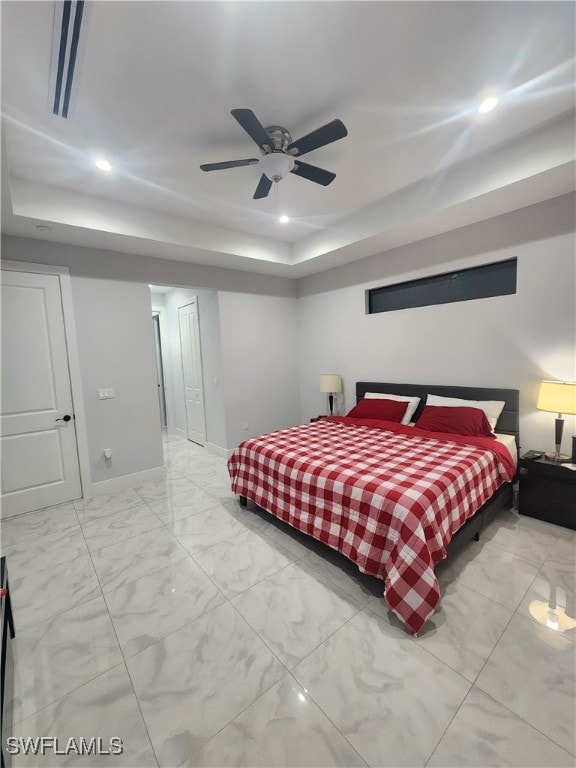 bedroom featuring ceiling fan and a tray ceiling