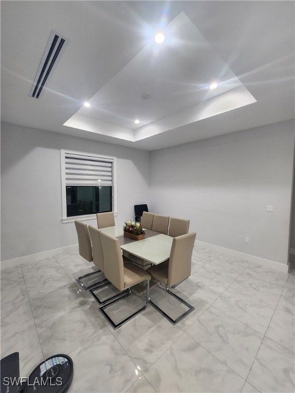 dining space featuring a raised ceiling