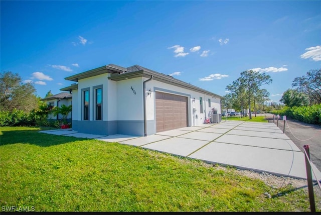 view of side of property featuring a garage and a lawn