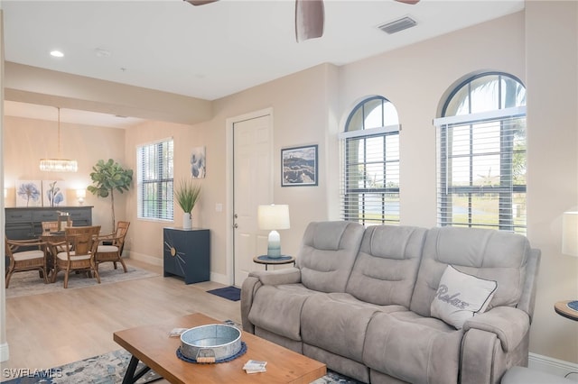 living room with plenty of natural light, ceiling fan, and light hardwood / wood-style floors