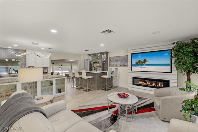 living room with recessed lighting, visible vents, and a glass covered fireplace