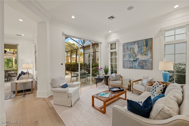 living room with plenty of natural light, ornamental molding, and light wood-type flooring