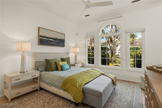 bedroom with crown molding, ceiling fan, and light hardwood / wood-style flooring