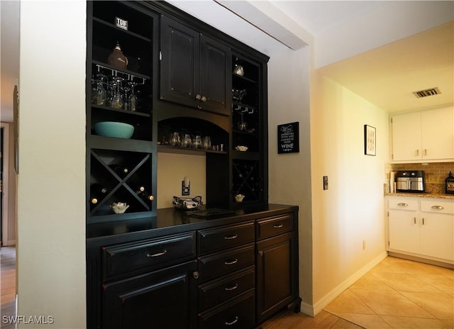 wine cellar with a dry bar, light tile patterned floors, baseboards, and visible vents