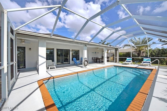 view of swimming pool featuring ceiling fan, a patio, and glass enclosure