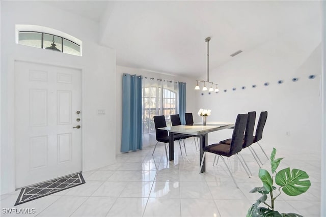 tiled dining room featuring lofted ceiling