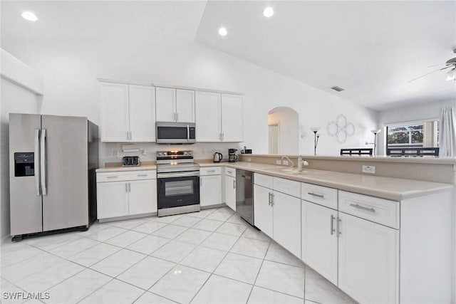 kitchen with sink, stainless steel appliances, white cabinets, light tile patterned flooring, and kitchen peninsula