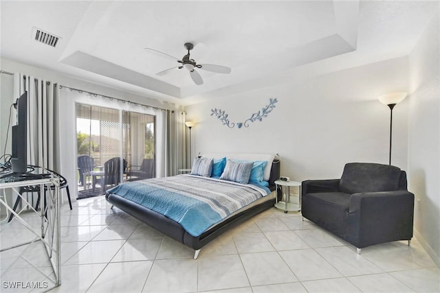 tiled bedroom featuring ceiling fan, access to exterior, and a raised ceiling