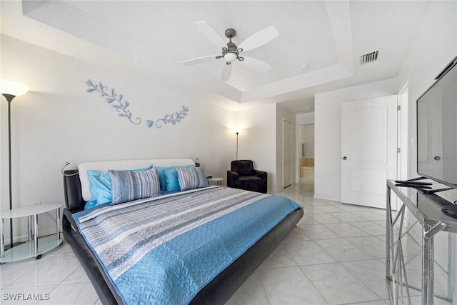 tiled bedroom featuring ceiling fan and a tray ceiling