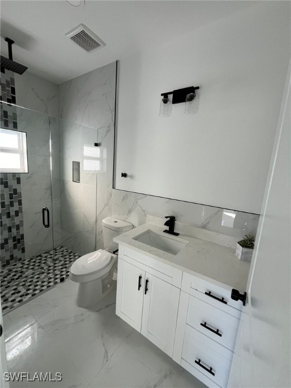 bathroom with vanity, toilet, and a shower with shower door