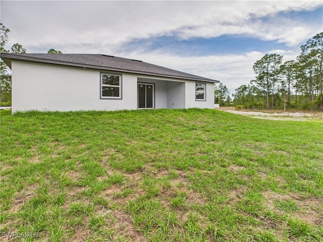 621 Allison St E, Lehigh Acres, FL 33974 - back of house featuring a yard and stucco siding