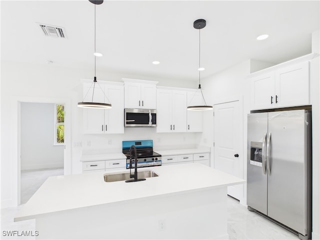 621 Allison St E, Lehigh Acres, FL 33974 - kitchen with a kitchen island with sink, white cabinetry, decorative light fixtures, light countertops, and appliances with stainless steel finishes