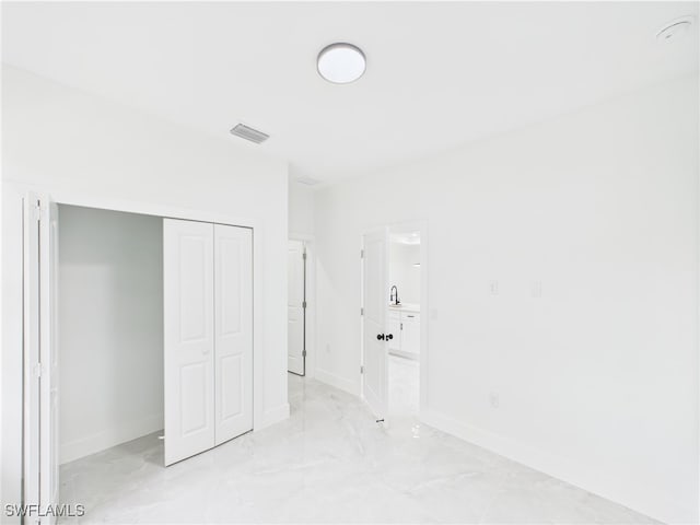 621 Allison St E, Lehigh Acres, FL 33974 - unfurnished bedroom featuring a closet, baseboards, marble finish floor, visible vents, and a sink