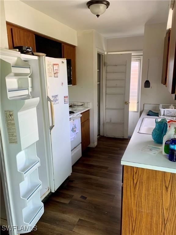 kitchen with dark hardwood / wood-style flooring and white appliances