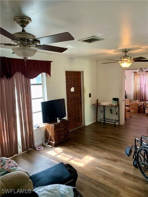 living room with wood-type flooring and ceiling fan