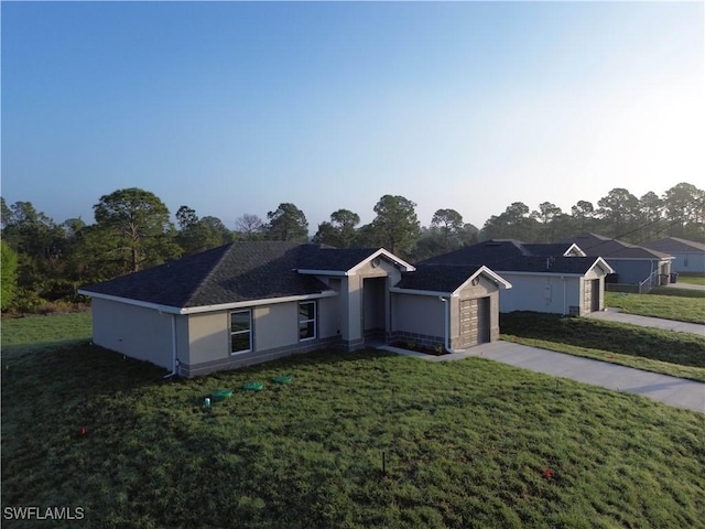 ranch-style home featuring a garage and a front lawn