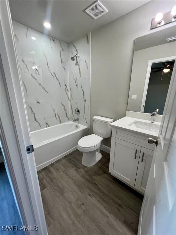 full bathroom with vanity, toilet, tiled shower / bath combo, and hardwood / wood-style floors