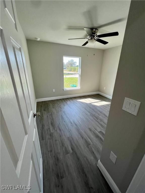 unfurnished room featuring dark hardwood / wood-style flooring and ceiling fan