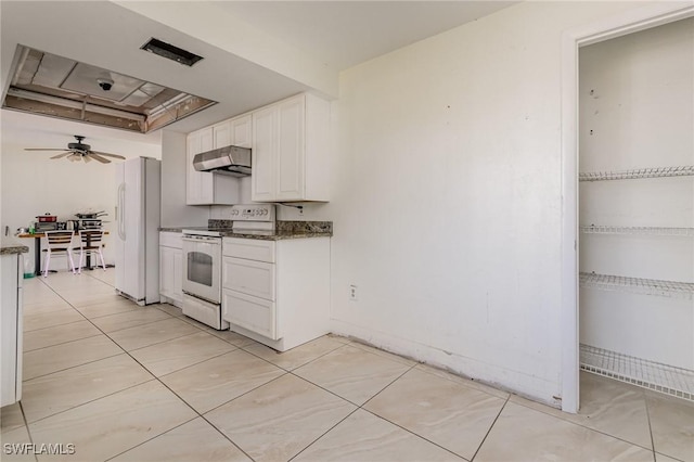 kitchen with white appliances, white cabinets, dark countertops, ceiling fan, and under cabinet range hood