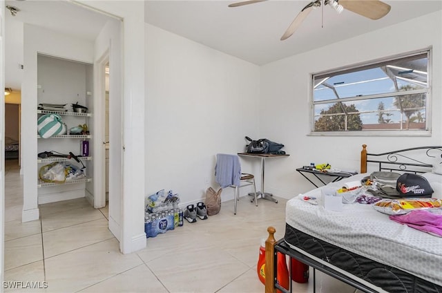 bedroom featuring ceiling fan, light tile patterned floors, and baseboards