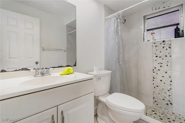 bathroom with a stall shower, vanity, and toilet