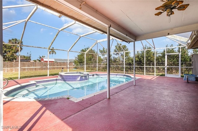 view of swimming pool featuring a lanai, a pool with connected hot tub, fence, and a patio