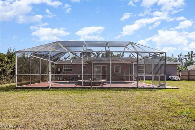 back of house featuring a lanai, a patio area, a lawn, and fence