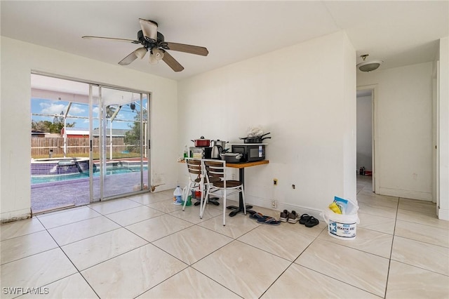 office area with ceiling fan, baseboards, and tile patterned floors