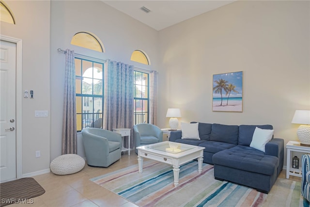 living room with light tile patterned floors and a high ceiling