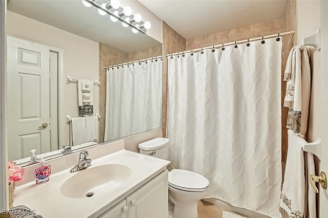 bathroom with vanity, curtained shower, and toilet