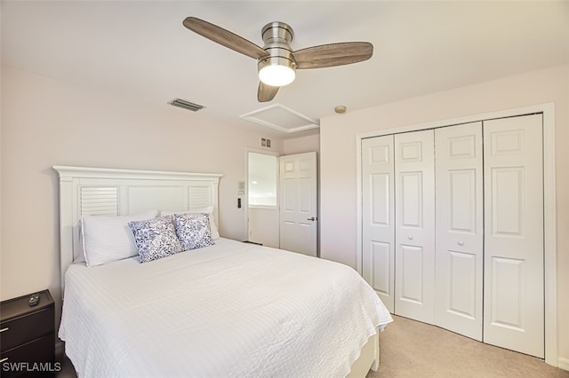 bedroom with ceiling fan, light colored carpet, and a closet