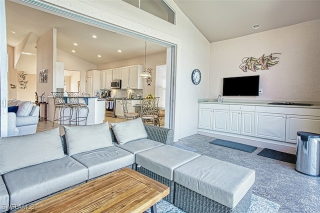 living room with vaulted ceiling and sink