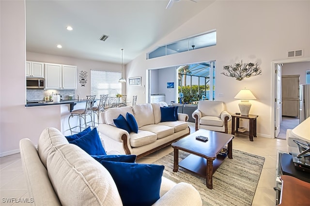 living room with light tile patterned floors and high vaulted ceiling