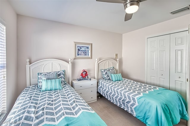 carpeted bedroom with ceiling fan and a closet