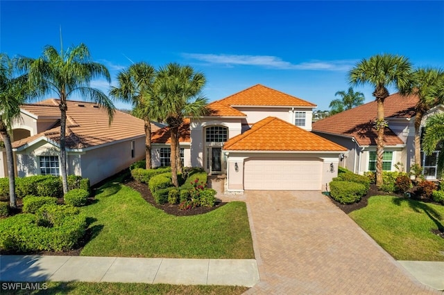 mediterranean / spanish-style home featuring a garage and a front yard