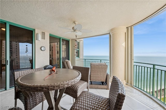 sunroom / solarium with a water view and ceiling fan