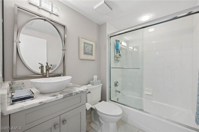 full bathroom featuring tile patterned floors, vanity, toilet, and combined bath / shower with glass door