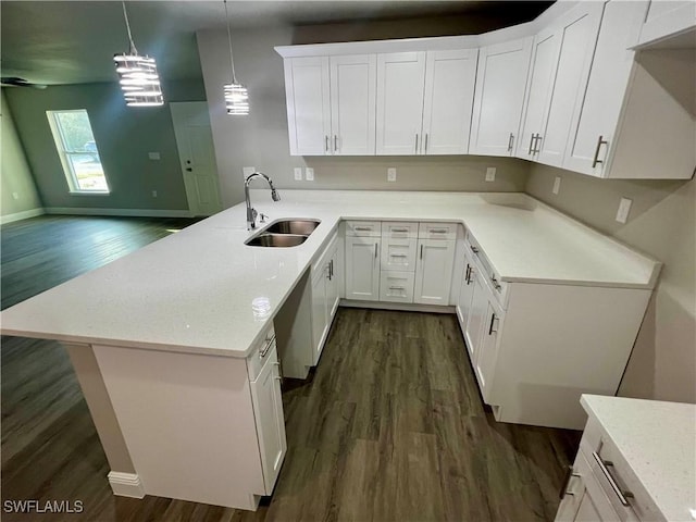 kitchen featuring sink, white cabinetry, decorative light fixtures, dark hardwood / wood-style flooring, and kitchen peninsula