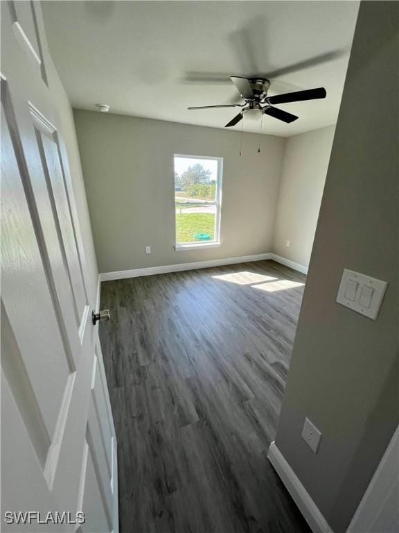 unfurnished room with dark hardwood / wood-style floors and ceiling fan