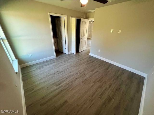 unfurnished bedroom featuring dark hardwood / wood-style floors and ceiling fan