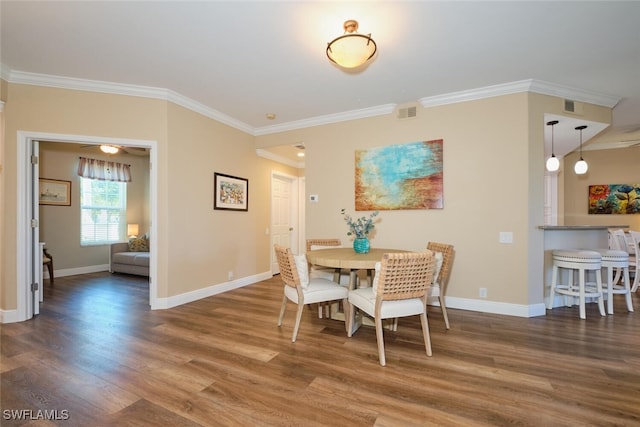 dining room featuring ornamental molding and dark hardwood / wood-style flooring