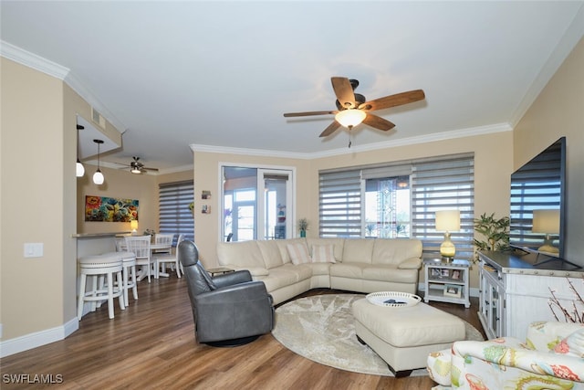 living room featuring ceiling fan, ornamental molding, and hardwood / wood-style floors