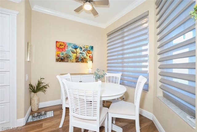 dining area featuring hardwood / wood-style floors, crown molding, and ceiling fan