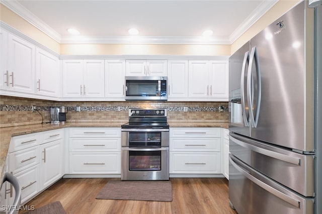 kitchen featuring stainless steel appliances, white cabinets, light stone counters, and light hardwood / wood-style flooring